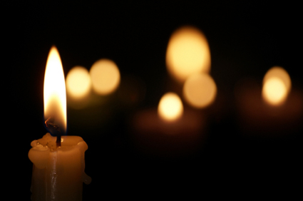 one burning candle with a few