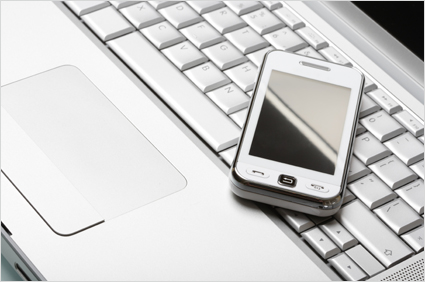 Modern communications concept. White communicator on silver laptop.