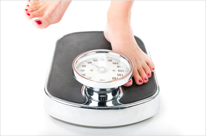 Young woman standing on a scale